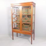 An antique mahogany display cabinet, with two lattice glazed doors and two fixed shelves.