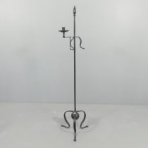 A wrought Iron candle stand in the form of an 18th century floor rushlight holder. Height 147cm.