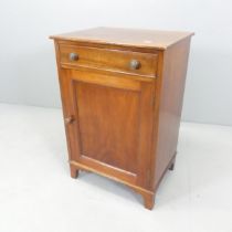 An early 20th century mahogany single door cabinet, with single drawer and raised on bracket feet.