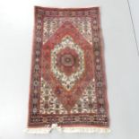 A cream-ground Persian mat. 112x76cm.