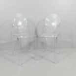 A pair of clear Perspex chairs in the manner of Philip Starck.