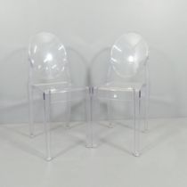 A pair of clear Perspex chairs in the manner of Philip Starck.