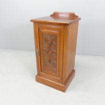 An Art Nouveau style mahogany pot cupboard with carved and panelled door. 40x81x36cm.