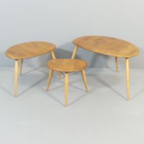 ERCOL - A nest of three pebble occasional tables, with blue maker's label. Largest 66x40x44cm.