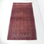 A red-ground Baluchi rug. 218x122cm. Fading to one end. Some fringe loss. Would benefit from a