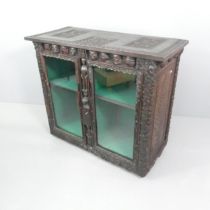 A Victorian carved oak cabinet, with chip carved greek key, floral and figural decoration, dated