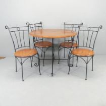 A modern mahogany circular topped garden table on cast iron base, 92x76cm, and four matching chairs.