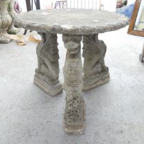 A weathered concrete low circular garden table on dragon supports. 58x51cm.