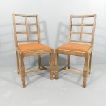 A pair of oak lattice back Cotswold school dining chairs in the manner of Heals. Good overall