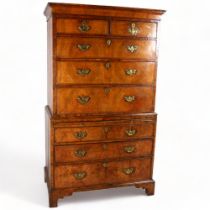 A 19th century walnut chest on chest, feather-banded drawer fronts with brushing slide, brass drop