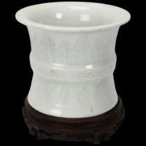 A Chinese white glaze porcelain brush pot, with incised leaf decoration, on hardwood stand, height