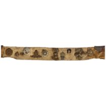 A World War 1 British Army canvas belt with attached regimental badges