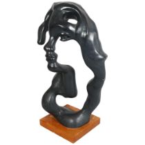 A abstract sculpture of a face, composite patinated material, on wooden base, overall height 56cm