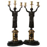 A pair of bronze candelabra supported by Classical figures, on oval marble bases, height 75cm All in