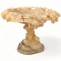 An Italian carved alabaster table centre tazza, with pierced leaf border and spiral dolphin