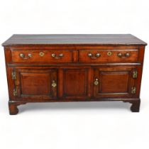 An 18th century oak dresser base, with 2 frieze drawers, 2 fielded panelled cupboards under and