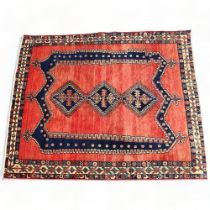 A mid-20th century Persian Afshar red and blue ground wool rug, with central lozenge panels and