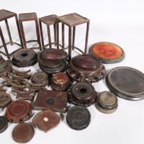 A collection of Chinese hardwood carved stands and jar covers