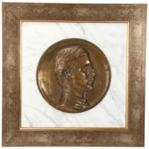 A bronze relief plaque depicting Wilfred Owen (1893 - 1918), set into white marble background in