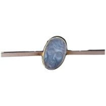 An early 20th century moonstone 'man in the moon' bar brooch, unmarked rose gold settings with