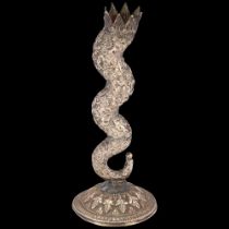 An Indian silver serpentine candlestick, early 20th century, allover relief embossed floral