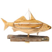 A modern sculpture of a fish, the mid-section of the fish has been cut away and replaced with a