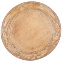 A 20th century bread board with carved decoration, diameter 29cm Board is in well-used condition,