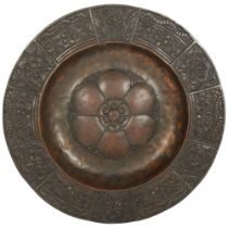 An Arts and Crafts hand chased and beaten bronze dish, 26cm