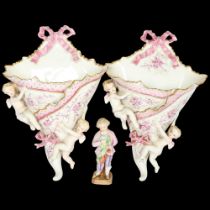 A pair of Continental porcelain wall pockets with applied cherubs, and a porcelain figure, boy