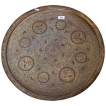 A large brass Indian table-top tray, diameter 57cm, decorated with floral decoration including