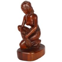 A carved hardwood sculpture of a kneeling woman, H34cm