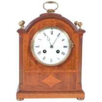 An Edwardian mahogany and satinwood-banded arch-top mantel clock, white enamel dial and Roman