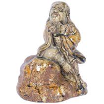 A 19th century Chinese porcelain sculpture of a seated figure on a rock, predominantly green