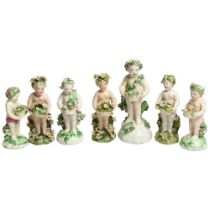 A group of 19th century cherub figurines, all decorated with floral garlands and headdresses,