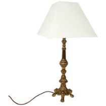 A decorative embossed brass table lamp and shade, height to top of bayonet fitting 58cm