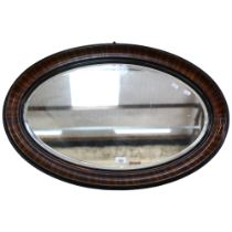 A large oval mahogany-framed mirror, bevelled glass, approx 53cm x 80cm
