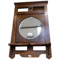 An Art Nouveau stained wood-framed wall mirror, with integral shelf, 57cm x 38cm