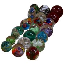 A collection of decorative coloured glass paperweights, and a plastic example