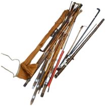 A collection of Vintage bamboo and other fishing rods, walking cane etc