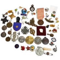 A collection of various military and other badges, pendants, medallions, etc