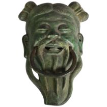 A bronze verdigris laughing Buddha door knocker, L20cm