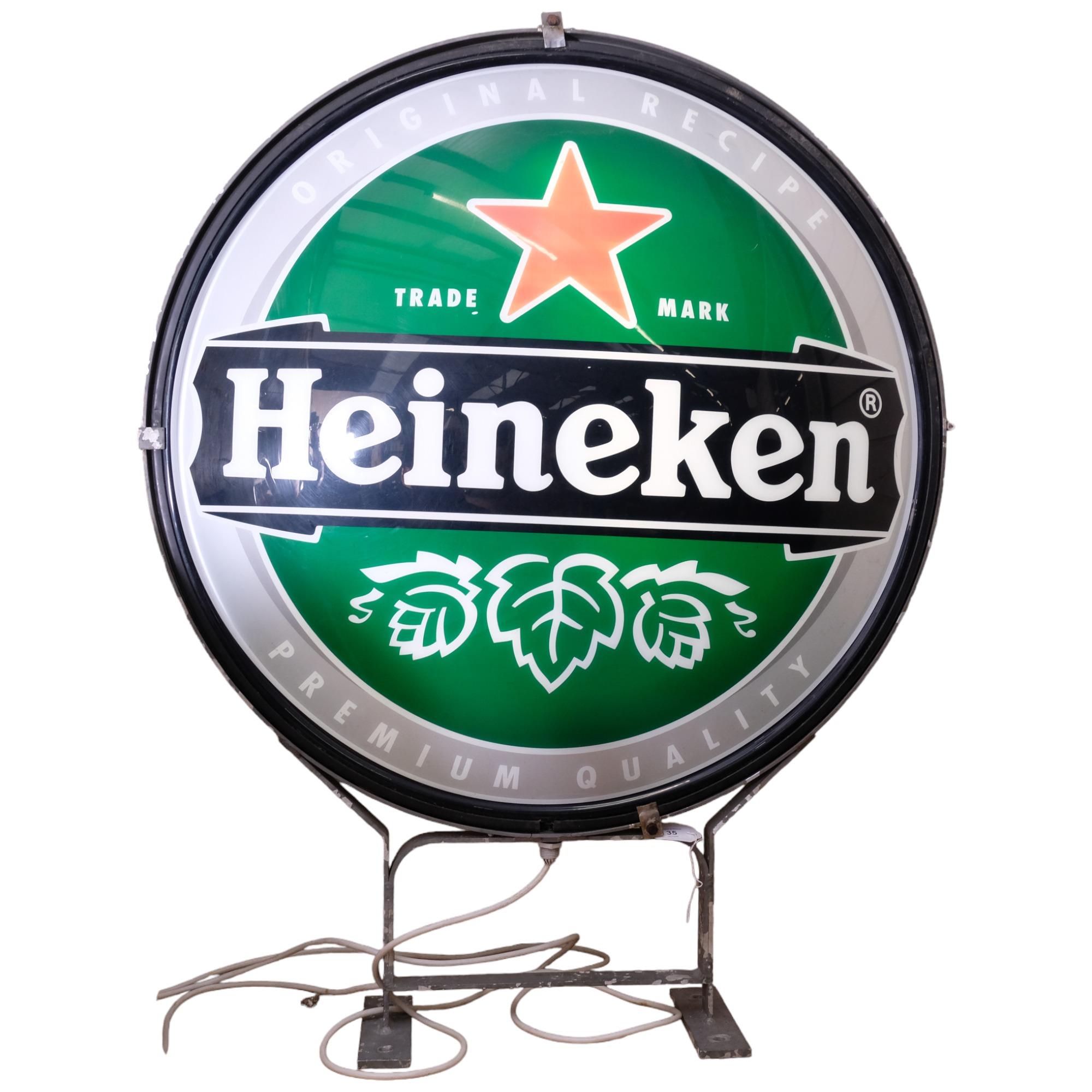 "Heineken", a large double-sided circular illuminated advertising sign for Heineken, on stand, H97cm