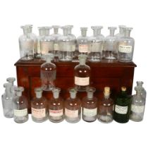 Antique oak box containing assorted glass chemist bottles with stoppers, with labels from various