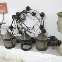 A pair of cast iron circular electric candelabra, diameter 63cm, and three hanging lanterns,