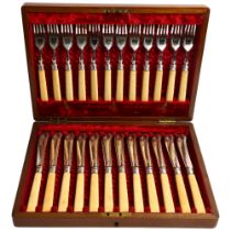 An early 20th century canteen of fish cutlery for 12 people, with engraved blades, in a fitted