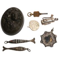 A relief carved jet brooch (lacking pin), 2 articulated fish fobs, a silver golf bag and clubs