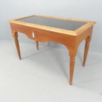 A modern stained pine display table, with glazed lifting top. 120x75x60cm. Internal depths 10cm