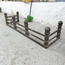 A cast iron Arts & Crafts style fire surround with ball finials. 122x28x38cm.