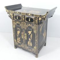 A contemporary Oriental black laquered altar cabinet, with gilt painted decoration, two drawers