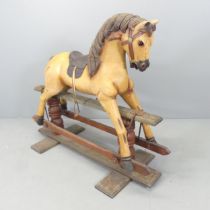 A painted wooden rocking horse. Overall 124x105x50cm. Good condition for age. Split to wood around